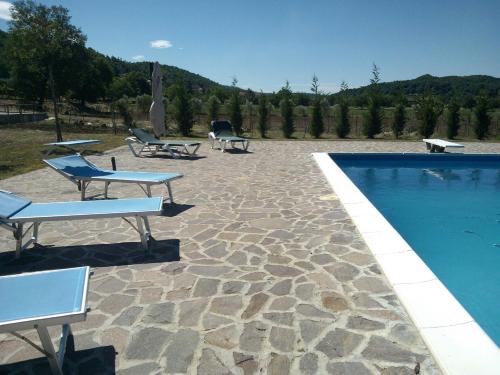 a swimming pool with lounge chairs next to at Tenuta Armida Relax & Pool in Liberi