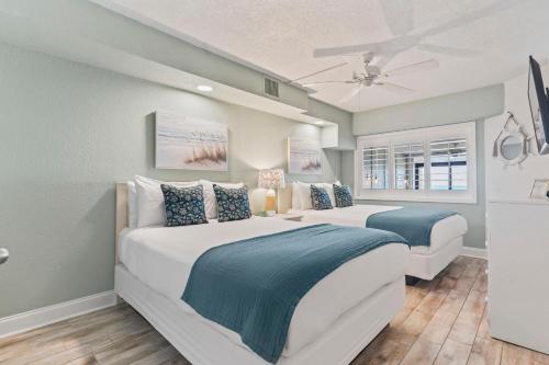 a bedroom with two beds and a ceiling fan at Ocean Front at Beach Cove in Myrtle Beach