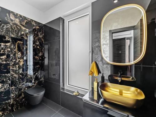 a bathroom with a gold sink and a mirror at Villa in Medulin with swimming pool in Premantura