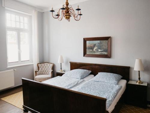 ein Schlafzimmer mit einem großen Bett und einem Kronleuchter in der Unterkunft Villa Romantica Lenzen in Körbitz