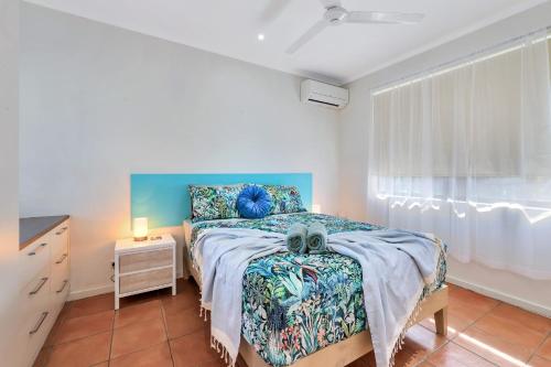 una camera da letto con un letto, un comò e una finestra di Ocean Vista Nightcliff Foreshore Apartment a Nightcliff