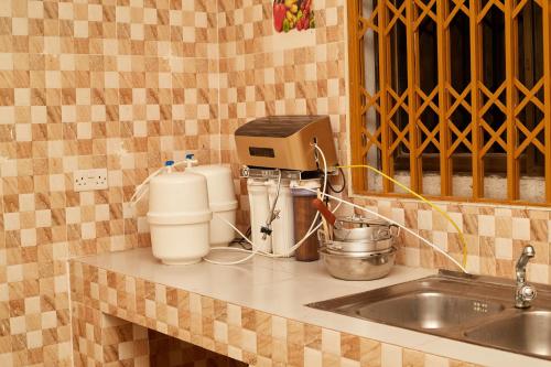 a kitchen counter with a mixer and a sink at Royal prima guest house, apartment and event center in Amanfro