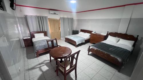 a bedroom with two beds and a table and a chair at Recidencial NUBE 69 in Santa Cruz de la Sierra