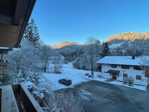a snow covered yard with a car parked in front of a house at Ferienhaus Gollbichl in Sachrang