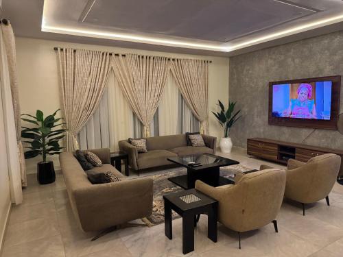 a living room with a couch and chairs and a tv at KumKum Apartments in Pakoto
