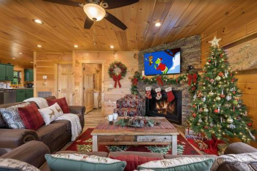 a living room with a christmas tree and a fireplace at Hibearnator in Sevierville