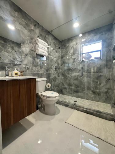 a bathroom with a toilet and a sink and a shower at New Lagoon-front townhouse with Marina Day Dreams Key Largo in Key Largo