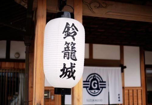 Una luz con escritura asiática en un poste. en 鈴籠城 籠の間 ダブルベッド2台 二段ベッド1台, en Nagahama