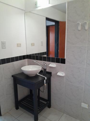 een badkamer met een wastafel en een spiegel bij La Morada de tus Sueños VCP con vista al LAGO in Villa Carlos Paz
