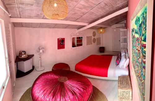 1 dormitorio con cama roja y sombrilla roja en PinkCoco Uluwatu - Constant Surprises & for Cool Adults Only, en Uluwatu