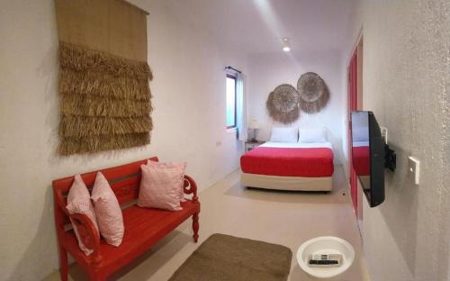 Un dormitorio con una cama y un sofá en una habitación. en PinkCoco Uluwatu - Constant Surprises & for Cool Adults Only, en Uluwatu
