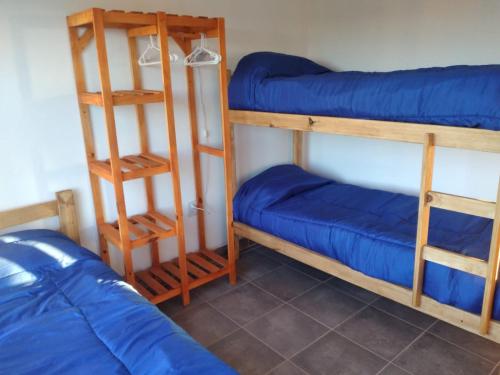 een kamer met 2 stapelbedden met blauwe lakens bij Mi Descanso in Balneario Claromecó