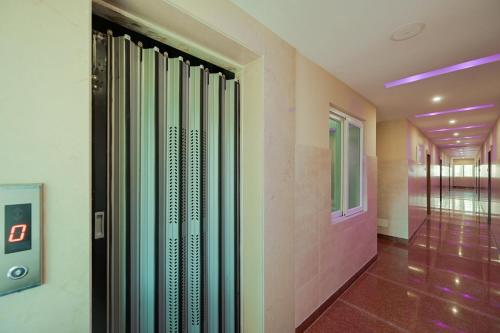 a hallway with glass shower doors in a building at Hotel O Blue Sagar in Puri