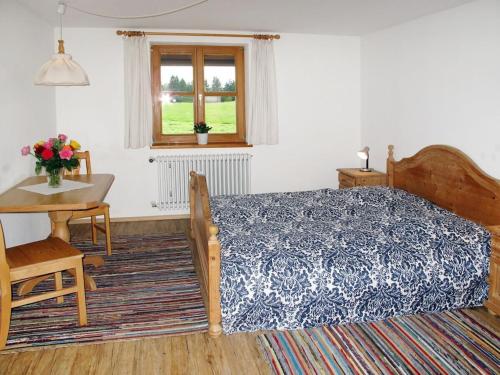 una camera da letto con un letto, un tavolo e una finestra di Holiday home with 2 bedrooms a Buchenberg