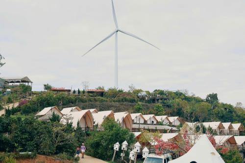 a large windmill in the middle of a town with houses at Cloud View Glamping Da Lat & Cloud 9 Săn Mây Cầu Đất in Da Lat
