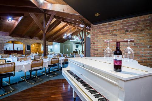 eine Weinflasche steht auf einem Klavier in einem Restaurant in der Unterkunft Wondai Colonial Motel & Ivory's Restaurant in Wondai