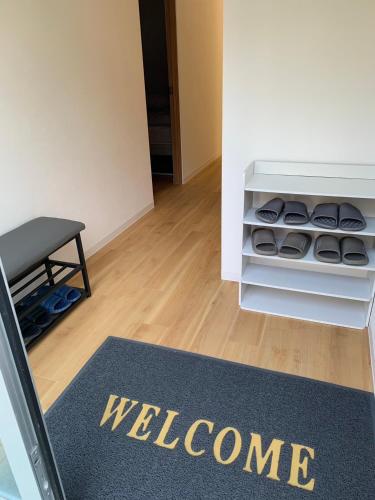 a welcome mat in a room with a welcome rug at hostel 丹鶴 in Shingū