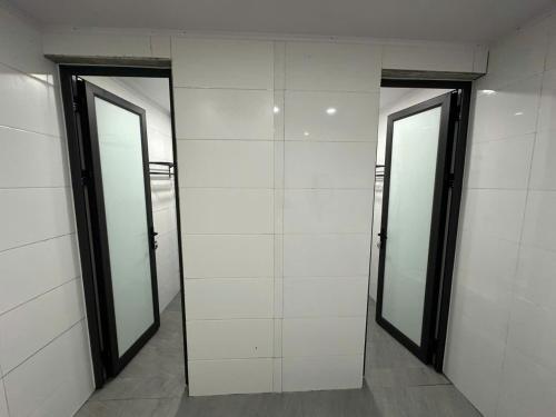 a row of three elevators in a building with three mirrors at Trúc Nhân Hotel in Dồng Văn