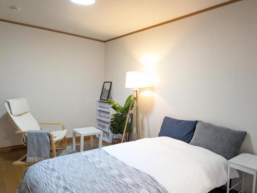 una camera da letto con un letto e una sedia di ann近島 無料駐車場2台 階段なし安心の平屋貸切 ファミリーやグループ旅行に最適 a Gifu