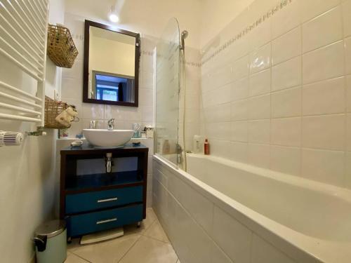 a bathroom with a sink and a tub and a mirror at Charmant T2 Larressore - Parking Privé - WiFi Inclus - FR-1-495-156 in Larressore