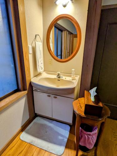 a bathroom with a sink and a mirror at Auberge Fujii Fermier in Fukui