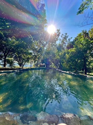 a pool of water in a park with the sun shining at Pepper Hills Hostel & Cottages in Ella