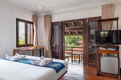 Postel nebo postele na pokoji v ubytování Ancient Luangprabang Hotel