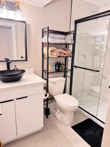 a bathroom with a shower and a toilet and a sink at NorthEdge Suites in Edmonton