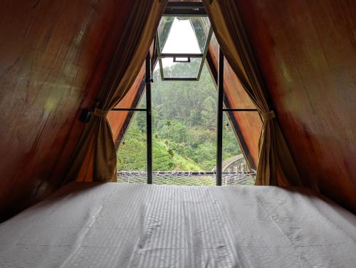 Schlafzimmer mit einem Bett und Blick auf ein Fenster in der Unterkunft Fern Hollow in Ella