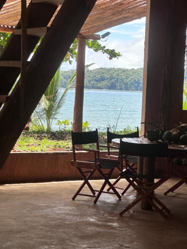 Una mesa y sillas con vista al agua. en Amparito Camp, en Santa Catalina
