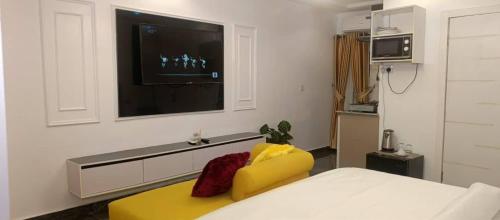 a room with a bed and a television on a wall at Micangelo shortlet apartment in Idimu