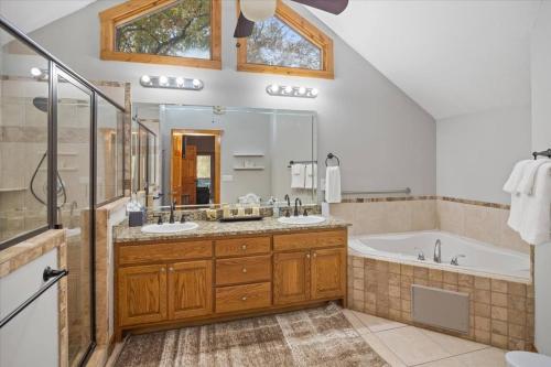 bagno con 2 lavandini, vasca e doccia di 4 BR Mountain Cabin with Hot Tub & Fire Pit in GA a McDaniel