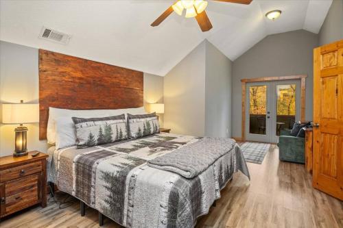 una camera da letto con un letto grande e un ventilatore a soffitto di 4 BR Mountain Cabin with Hot Tub & Fire Pit in GA a McDaniel