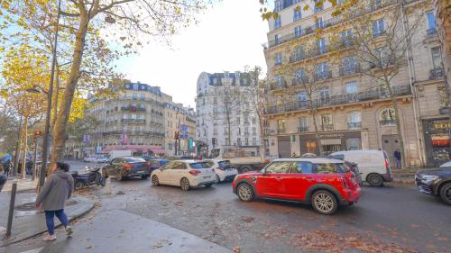 una concurrida calle de la ciudad con coches aparcados en la calle en 12 Lovely Studio Steps from Boulevard Saint Germain, en París