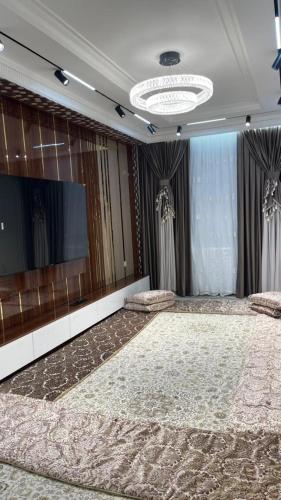 ドゥシャンベにあるАшанのテレビと大きなカーペットのある部屋