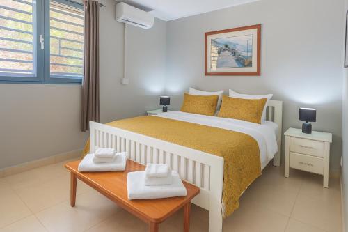 a bedroom with a bed and a table with towels on it at The Tree House Port Vila in Port Vila