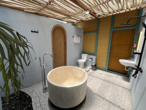a bathroom with a bath tub and a toilet at Onsen Resort Kaliurang in Mantaak