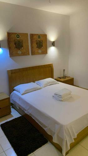 a bedroom with a bed with white sheets and pillows at Vila verde Resort in Santa Maria