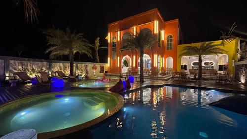 a swimming pool in front of a building at night at Onsen Resort Kaliurang in Mantaak