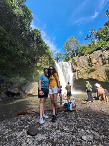 two women standing in front of a waterfall at Ubud Classic Day Trip in Pesanggaran