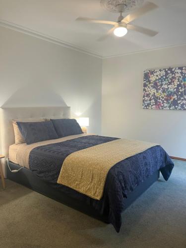una camera da letto con un letto e un ventilatore a soffitto di Cheerful 2 bedroom townhouse with secure parking a Mildura