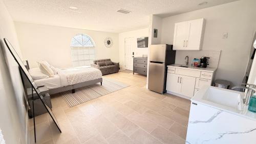 a kitchen and living room with a refrigerator and a couch at Hermoso apartaestudio en Orlando in Orlando