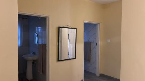 ein Badezimmer mit Waschbecken und Spiegel an der Wand in der Unterkunft Hatfield staylax Manor 2 in Harare