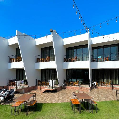 格兰岛Lastsearesort ลาสซี รีสอร์ท的一座前面有桌椅的建筑物