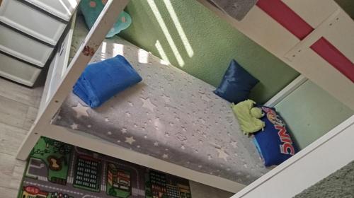 ein Puppenhaus-Etagenbett mit zwei blauen Kissen in der Unterkunft Panonska jezera ZELENA OAZA in Tuzla