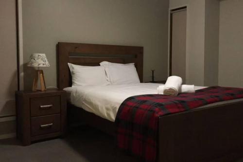 Geelong 3 Bedroom Lovely House في Hamlyn Heights: غرفة نوم مع سرير و كومودينو مع لحاف أبيض