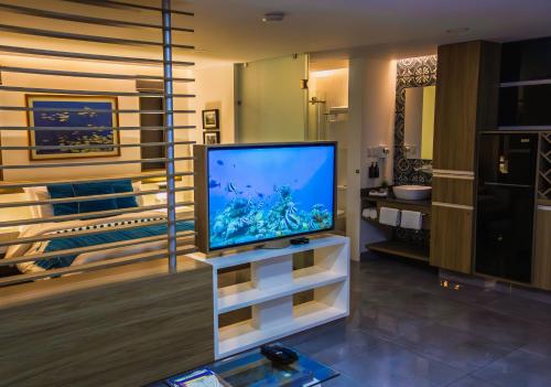 een woonkamer met een flatscreen-tv op een standaard bij The Lu'um House in Tuxtla Gutiérrez