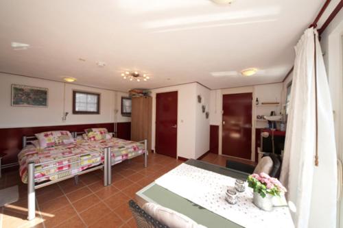 sala de estar con cama, mesa y sofá en B&B Dirosa en Onderdijk