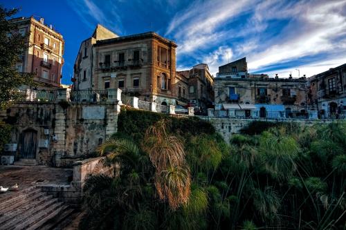 ein altes Gebäude mitten in einer Stadt in der Unterkunft Ortigia Deluxe S.A.L. in Syrakus