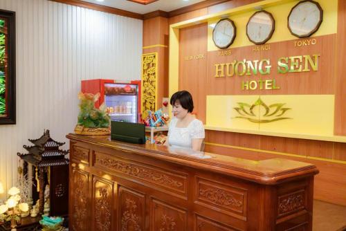 宁平Hương Sen Hotel的坐在台子里的女士,手提电脑